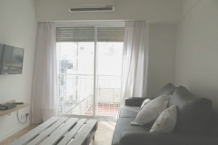 Living roome with flat LED 32" TV, Air conditioner and sofa bed.